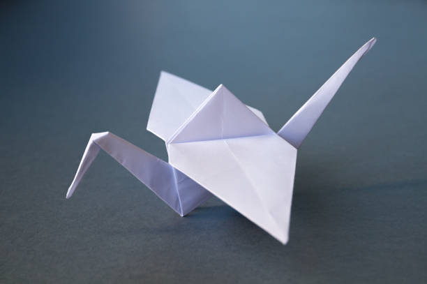 istock White paper crane origami isolated on a grey background 1411156683