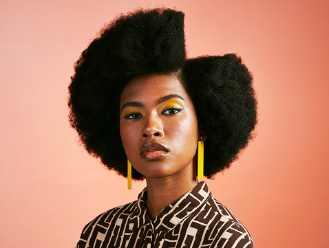 Modelo de cubierta afro de moda con actitud feroz y poderosa y peinado funky y moderno con una parte lateral simétrica. Poderoso retrato de mujer intensa, retro y melanina sobre fondo de estudio photo