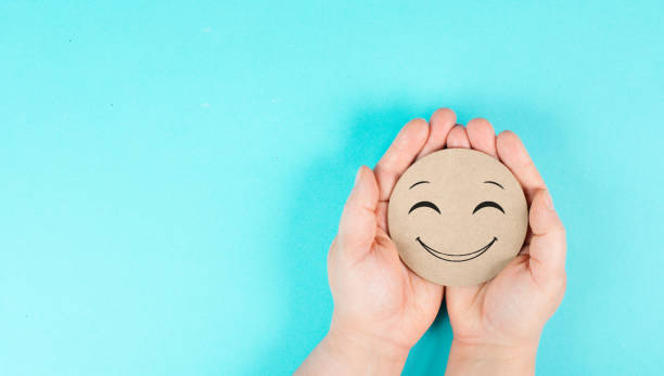istock Holding a smiling happy face in the hands, positive emotions, good customer feedback 1411159691