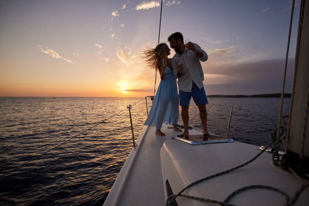 istock Young cheerful couple dancing on a yacht at sunset. 1411159702