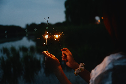 A girl playing fireworks at night