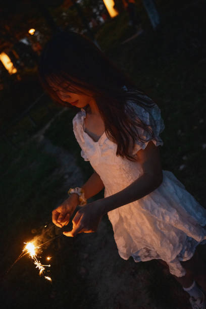 istock A girl playing fireworks at night 1411161199