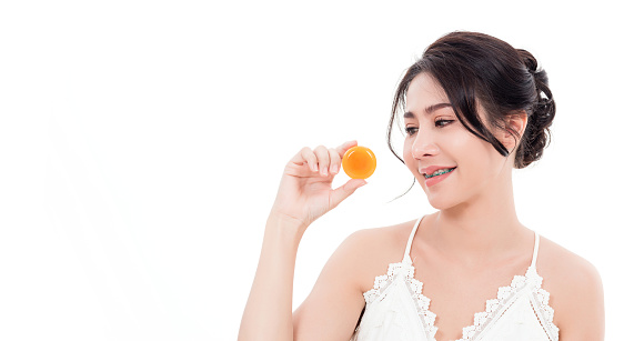 Asian young beautiful woman smiling she's holding orange handcrafted organic soap skin care near face for present product isolated on over white background, Beauty Zero waste concept