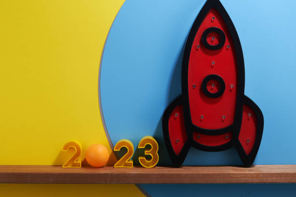 istock number 2023 and decorative rocket on blue and yellow background . 1411163597