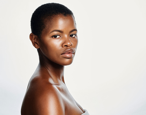 Portrait of cover model with attitude representing proud black beauty, perfect complexion and skintone. Face, headshot of a beautiful, confident and edgy woman with buzzcut hair and healthy skincare