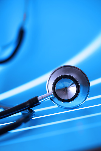 Stethoscope on pastel blue background with lighting effect