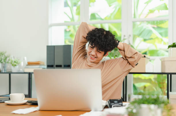 istock Woman holding her back pain while working on computer at home. 1411168416