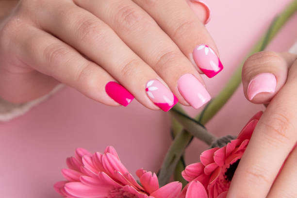 istock Female hands with pink manicure, flowers design 1411168553