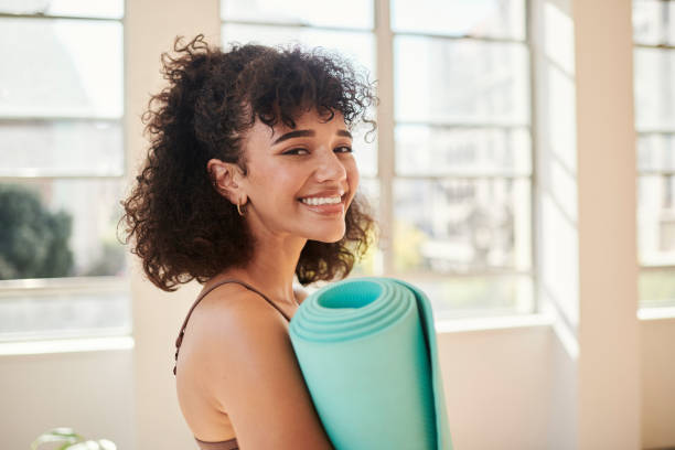 istock Feeling calm and at peace after a relaxing meditation class using her yoga mat for peace and spirituality. Happy yogi done or getting ready for mental health exercise for inner balance and peace. 1411171714
