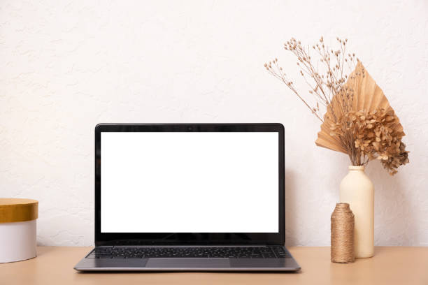 istock Laptop computer with blank screen, dried grass bouquet and vases. Aesthetic influencer boho styled interior design template with mockup laptop, copy space 1411171750