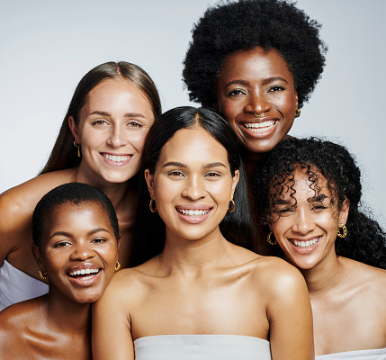 Portrait of diverse and happy beauty women feeling confident and comfortable in their skin. Different females with beautiful faces and good skincare, smiling while standing against grey background