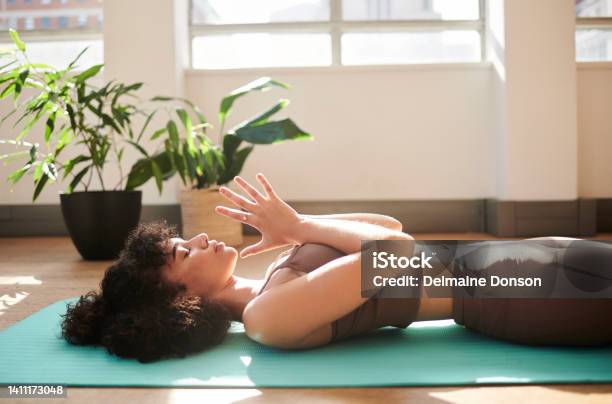 An Active And Mindful Woman Meditating In Her House As Part Of Her Morning Exercise Routine A Fit Female Doing Yoga At Home Training Her Balance And Body Strength An Athletic Lady Doing A Workout Stock Photo - Download Image Now