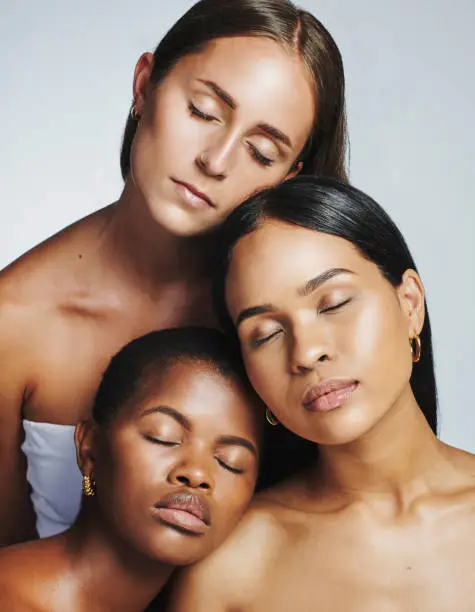 Faces of multiethnic and sensual beauty women feeling confident and comfortable in their skin. Closeup of different race females with beautiful and clear skin tones, isolated against grey background
