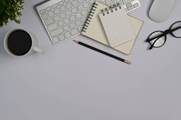 istock Above view magnifying glass, financial document, notebook and glasses on white office desk. 1411178209
