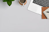 istock Minimal workplace with laptop computer, coffee cup, notebook and houseplant. Top view with copy space. 1411178215