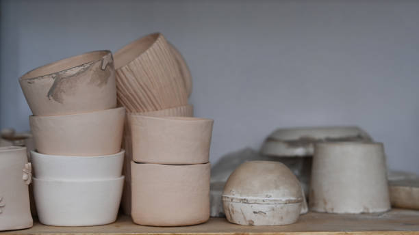 istock Handmade ceramic crockery on wooden shelf in creative studio. 1411178290