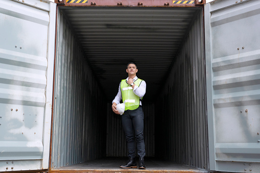 logistic worker is working at container ware house. Blue collar concept.