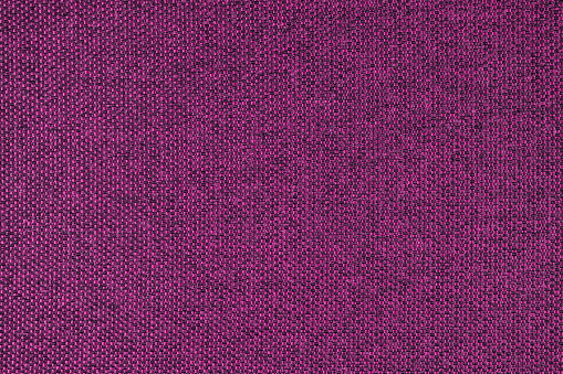 Close-up texture of natural purple coarse weave fabric or cloth. Fabric texture of natural cotton or linen textile material. Blue canvas background. Decorative fabric for upholstery, furniture, walls