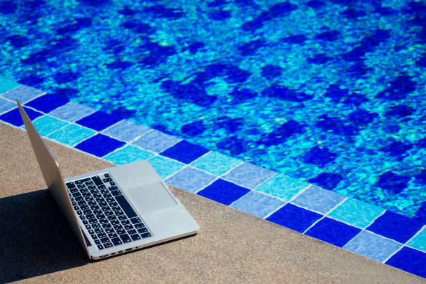 istock laptop at the pool, remote work on holiday freelance and frilansing concept 1411179954