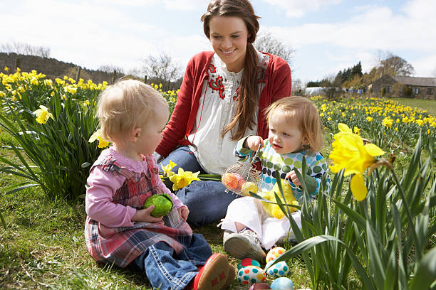 istock Mother And Daughter In Daffodil Field With Decorated Easter Eggs 141118015
