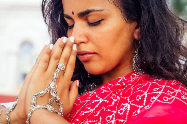 młoda hinduska w tradycyjnym czerwonym stroju sari modląca się w hinduskiej świątyni goa india hinduizm.dziewczyna wykonująca gest namaste katolicyzm delhi street holi festival.om medytacja jogi kobieta modelka - india goa temple indian culture zdjęcia i obrazy z banku zdjęć