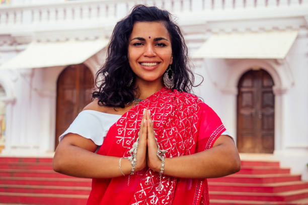 junge indische frau in traditionellem sari rotes kleid betet in einem hinduistischen tempel goa indien hinduismus.mädchen führt namaste geste katholizismus delhi street holi festival.om yoga meditation weibliches modell - bollywood prayer position indian culture indian ethnicity stock-fotos und bilder