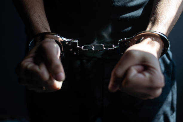 istock male hands in handcuffs black background 1411181087