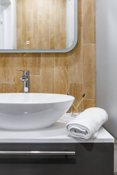 istock Large mirror over vessel sink in stylish bathroom interior 1411182431