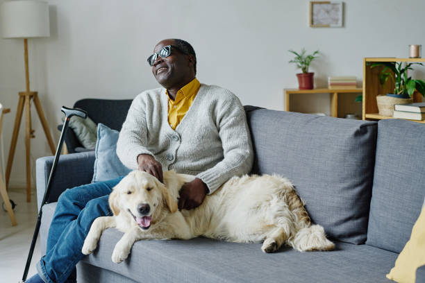istock Blind man with guide dog at home 1411182596