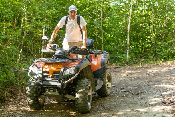 homme quad dans la forêt - off road vehicle quadbike mud dirt road photos et images de collection