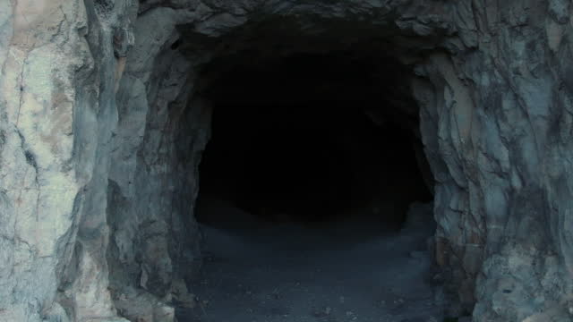 Entrance into a cave in the mountain with blackout in the end