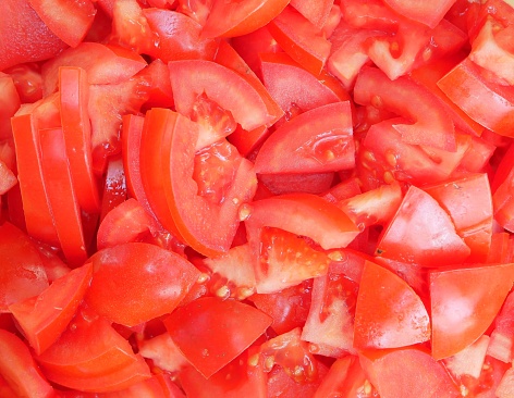Large red delicious tomatoes sliced for salad. Vitamin food for vegetarians, ready to eat. Ripe fragrant vegetables without spices.