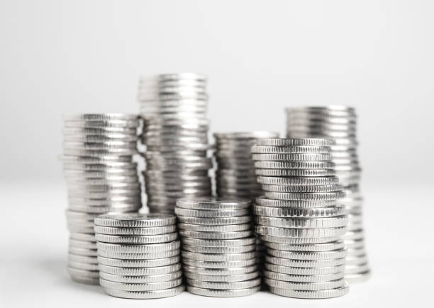 Many Euro coins stacked on white background, closeup