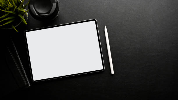 istock Modern black workspace top view with digital tablet mockup, stylus pen, and copy space. top view 1411184936