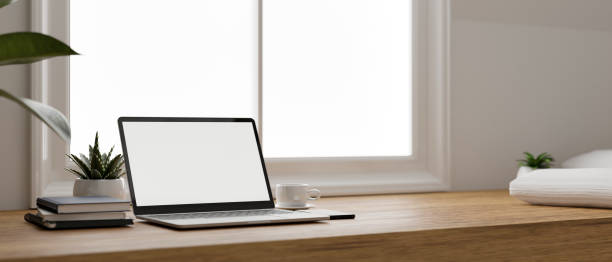 istock Minimal and comfortable home working space with laptop on wood tabletop against the window. 1411184978
