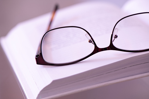 A pair of reading glasses on an open book
