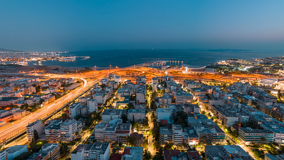 aerial panoramic photo of south of athens, Greece, over neo faliro, Pireas, Moschato, marina, poseidonos and kifissos avenues at night