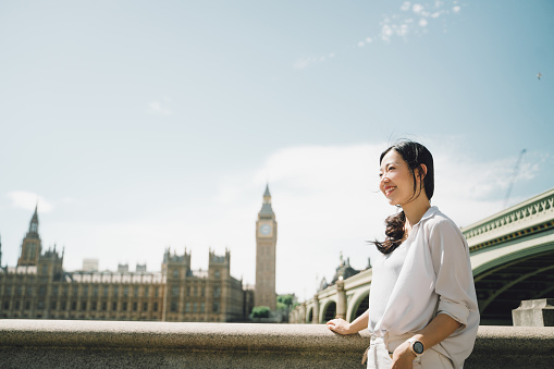 Beautiful Asian woman standing in front of Big Ben, London.