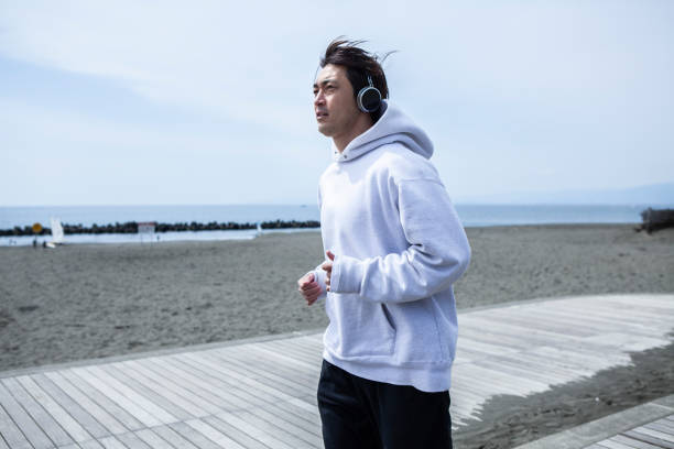40s Japanese sportsman who runs while listening to music on the beach.