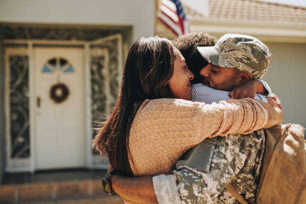 Military serviceman reuniting with his family at home stock photo