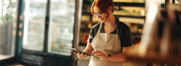 istock Happy supermarket owner using a digital tablet in her shop 1411191718