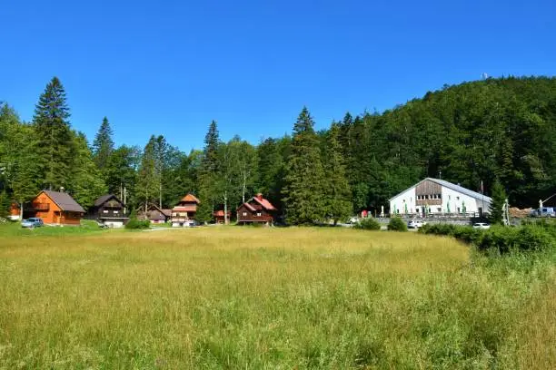 Meadow and mountain hut at Sviscaki at the trailhead for Sneznik in Notranjska region of Slovenia