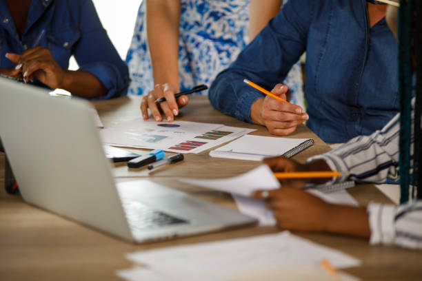 istock Close up shot of unrecognizable, diverse businesswomen analyzing various documents during a meeting 1411202088