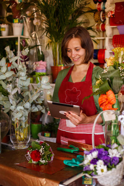 istock Florist using digital tablet when making flower arrangements for customers 1411202562