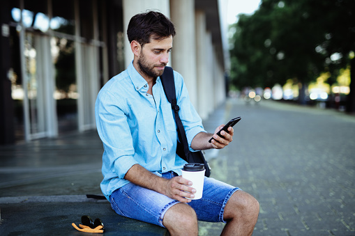 Adult man using smart phone on the go
