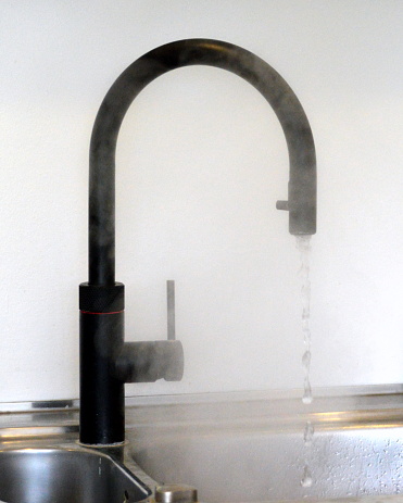 Black pull-down kitchen faucet with a single handle. It also delivers instant boiling water.