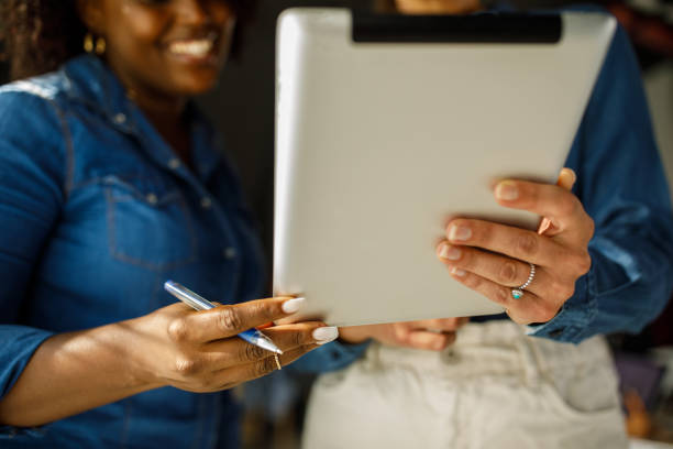 istock Two diverse businesswomen analyzing data on a digital tablet they are holding 1411207126