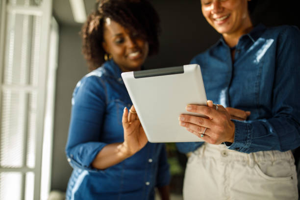 istock Close up shot of two female colleagues looking at project data on digital tablet 1411207130