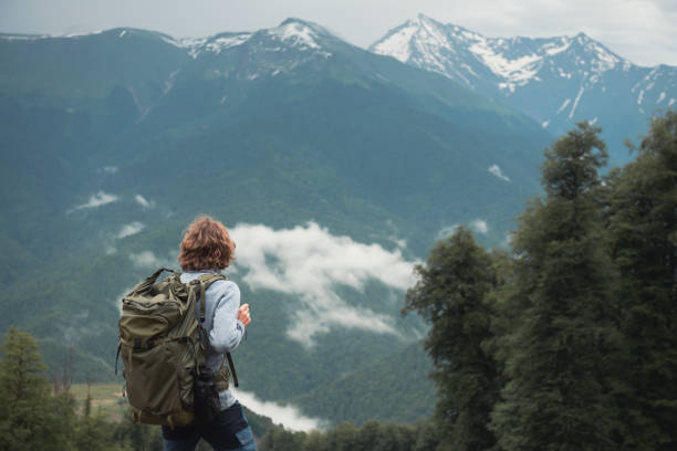 istock Man traveler with backpack hiking in the mountains. 1411207400