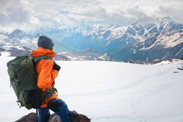 istock Man traveler with backpack hiking in the mountains. 1411207401